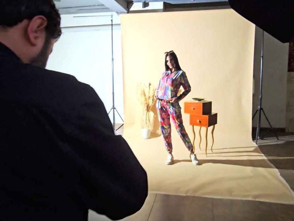 Close-up of a model highlighting the details of a clothing brand outfit during a product photography session.